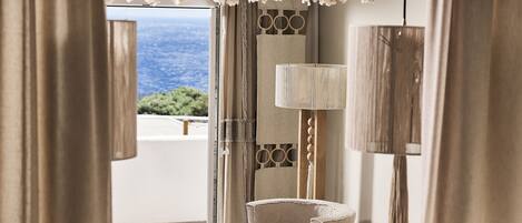 Una habitación con vista al mar, una lámpara y una silla.