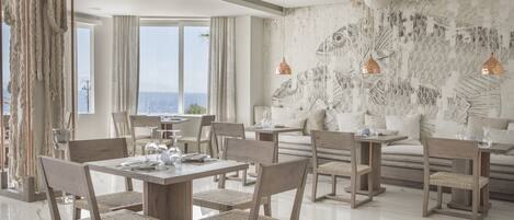 A modern dining area with wooden furniture and a large fish mural on the wall.