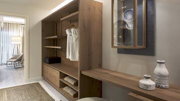 Une salle de bain moderne avec un meuble-lavabo en bois, un porte-peignoir suspendu et un élément décoratif en verre.