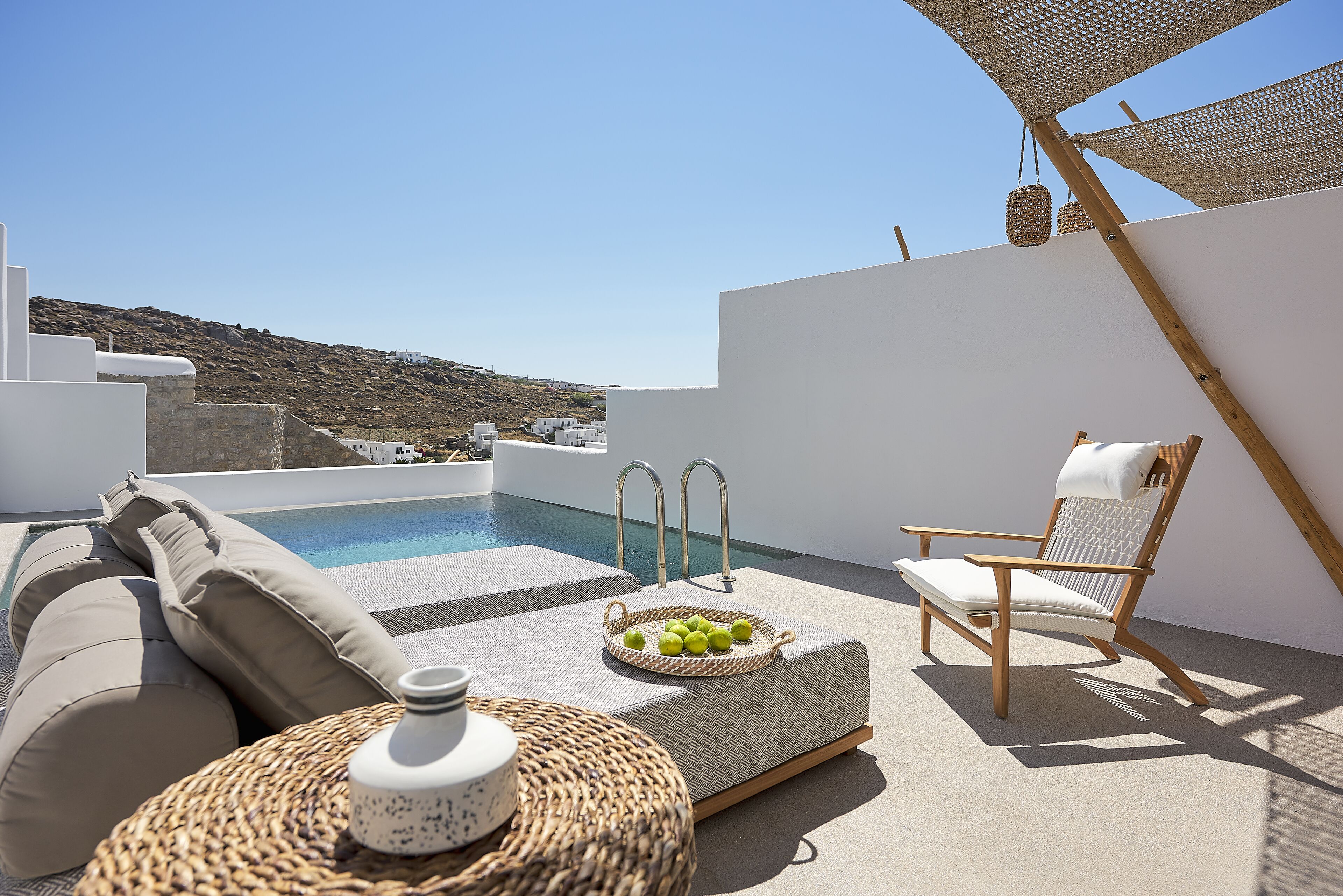 A rooftop terrace with a pool, lounge area, and outdoor seating.