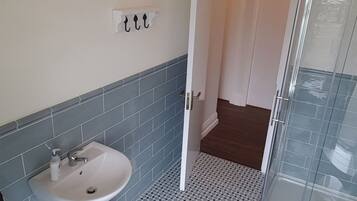 A bathroom with a sink, toilet, and shower.