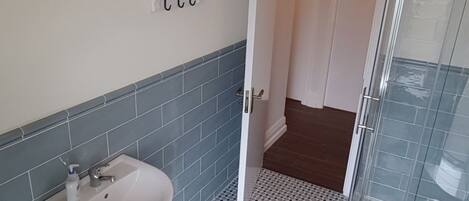 Un baño con lavamanos, inodoro y ducha.