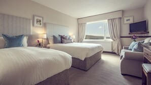 A hotel room with two beds, a sofa, a TV, and a window with curtains. - The Ardagh Hotel & Restaurant (Clifden)