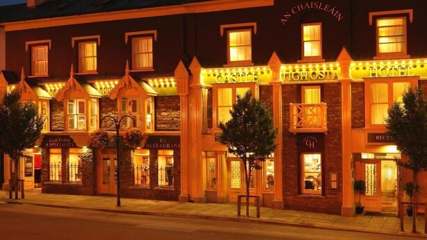 A hotel with a castle-themed facade, including a sign for 'Castle Tighhosta Hotel' and a 'Bar Food & Speciality' sign. - Castle Hotel Macroom (Macroom)