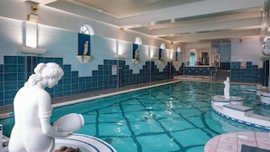 A swimming pool with a statue of a woman holding a vase, tiled walls, and a sign indicating a no swimming zone. - Castle Hotel Macroom (Macroom)