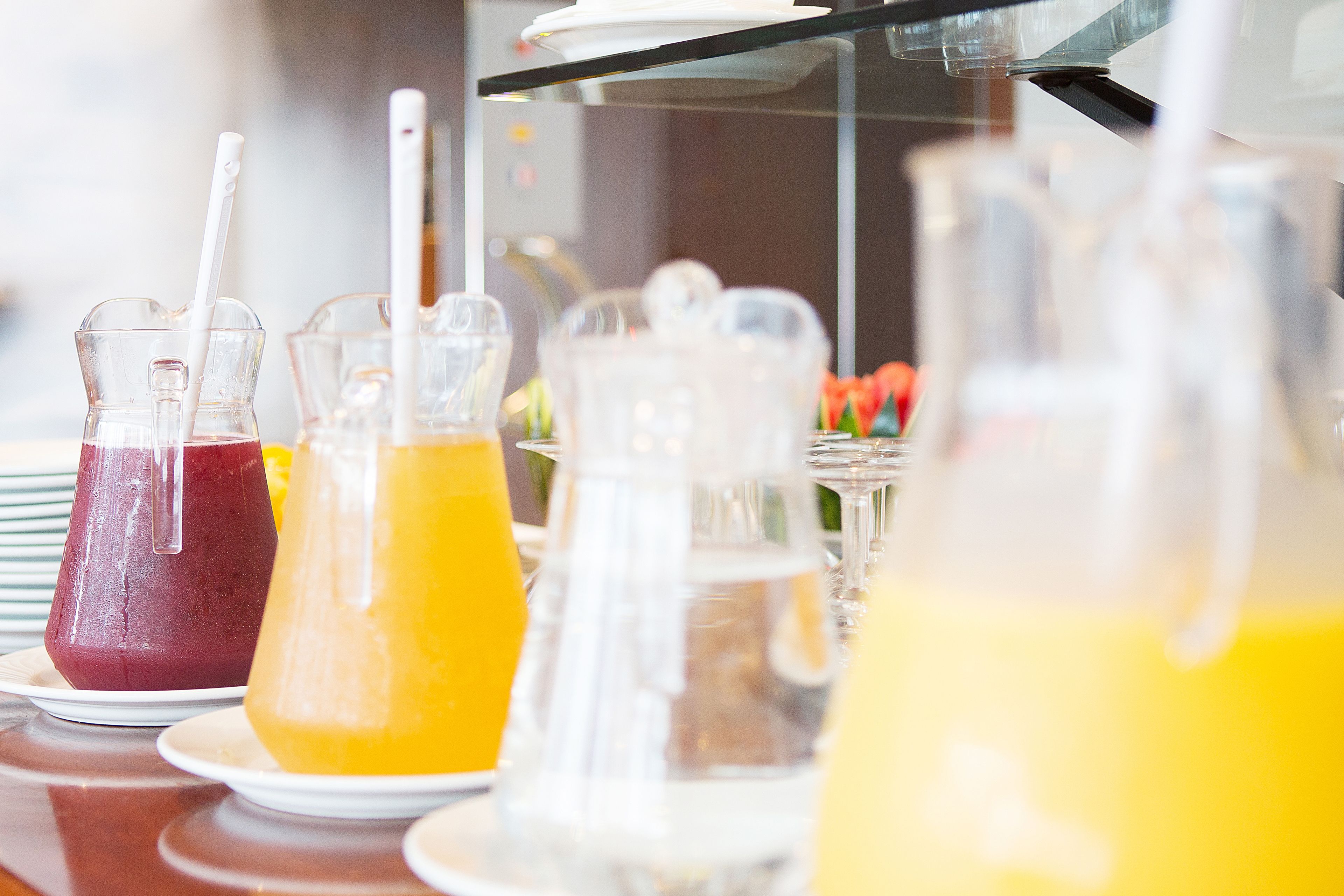 Une table de buffet avec divers types de boissons servis dans des carafes et des verres.