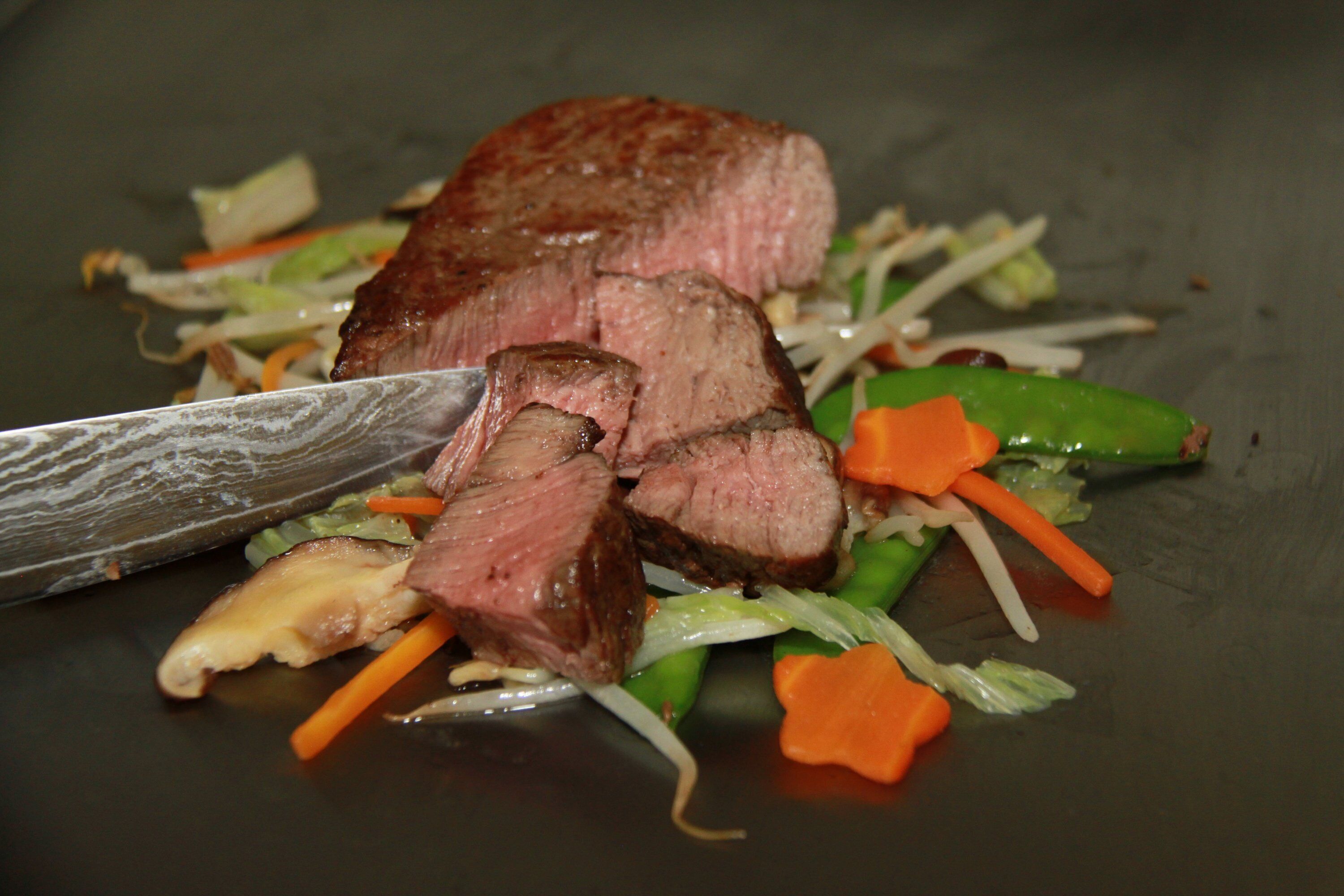 A steak with vegetables on a plate.