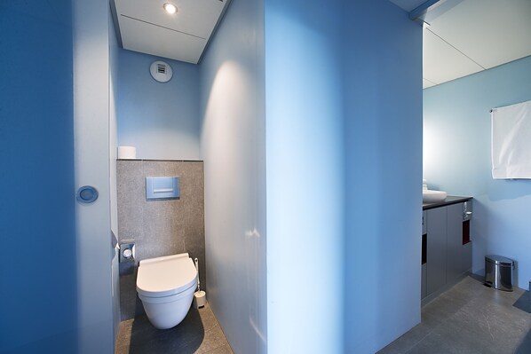 A modern bathroom with a toilet, bidet, and sink.