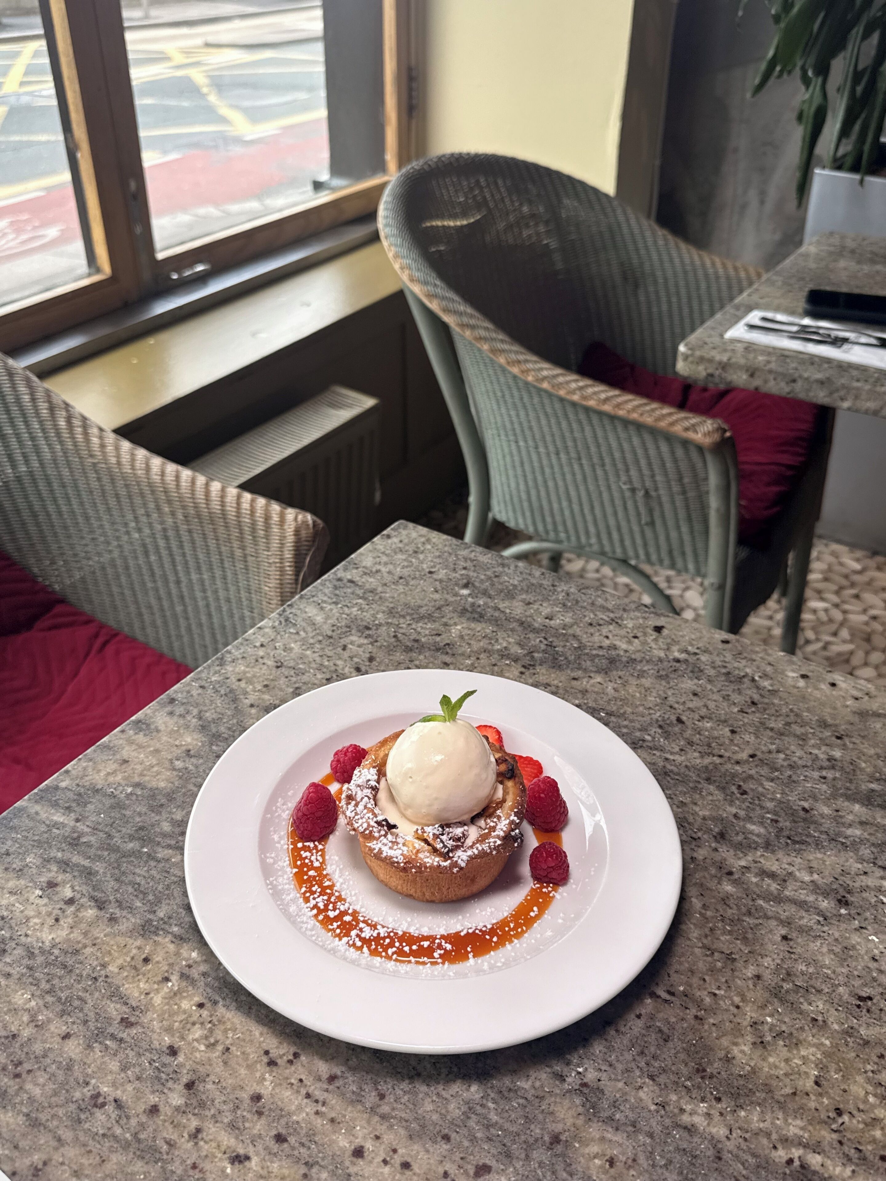 Dessert auf einem Teller mit Blick aus dem Fenster.