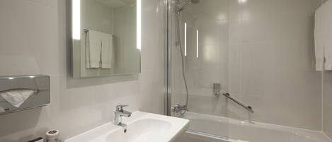 A modern bathroom with a white sink, a glass-enclosed shower, and a bathtub.