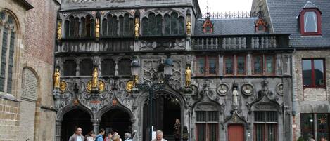 Un edificio histórico con detallada labor de cantería, múltiples arcos y estatuas.