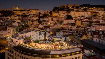 Une vue nocturne d’une ville, avec une foule importante rassemblée sur un toit.