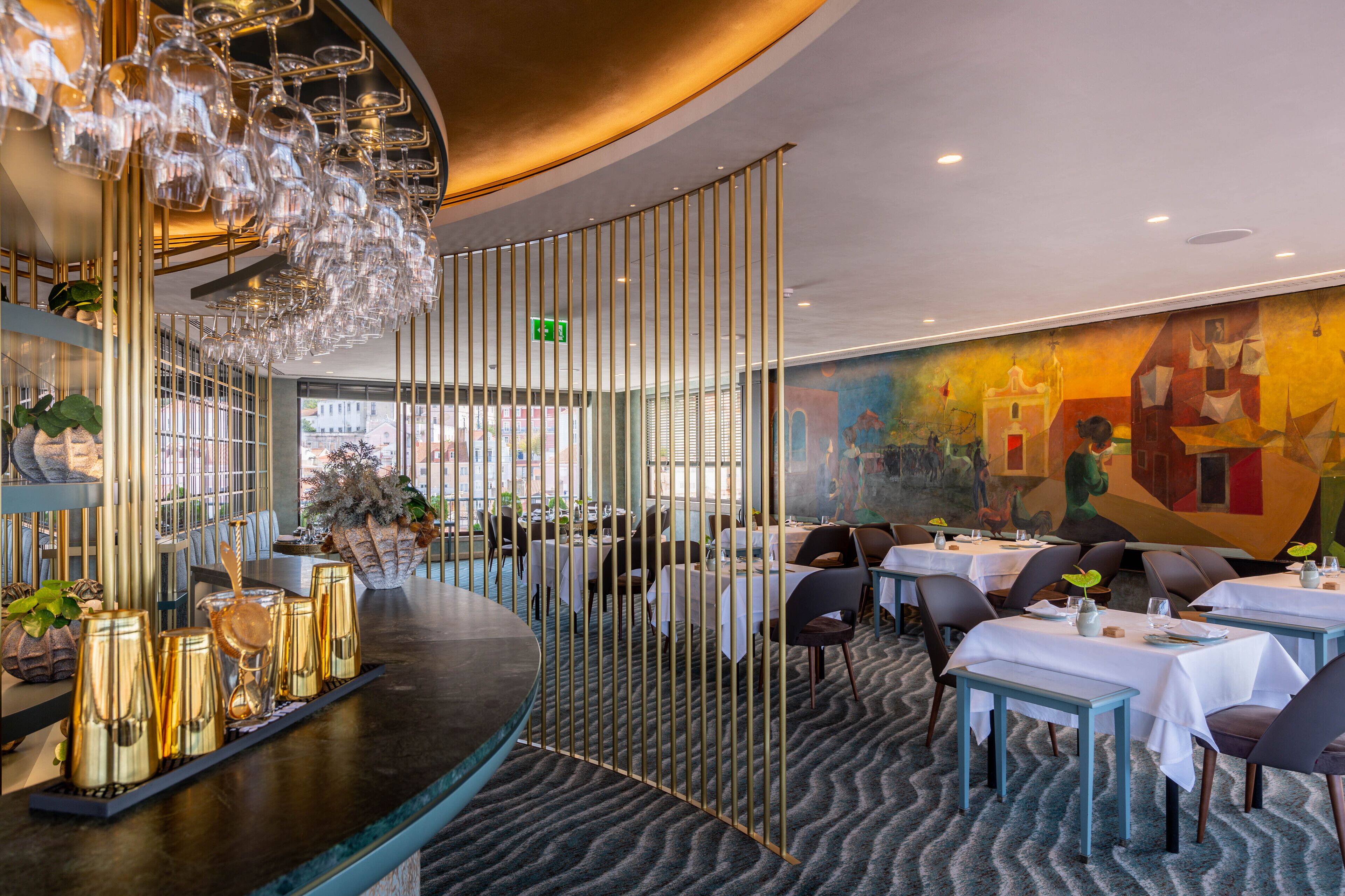 Ein Restaurant mit modernem Interieur, das eine Bar mit einer besonderen Glaspräsentation, Tische für das Essen und ein farbenfrohes Wandgemälde bietet.