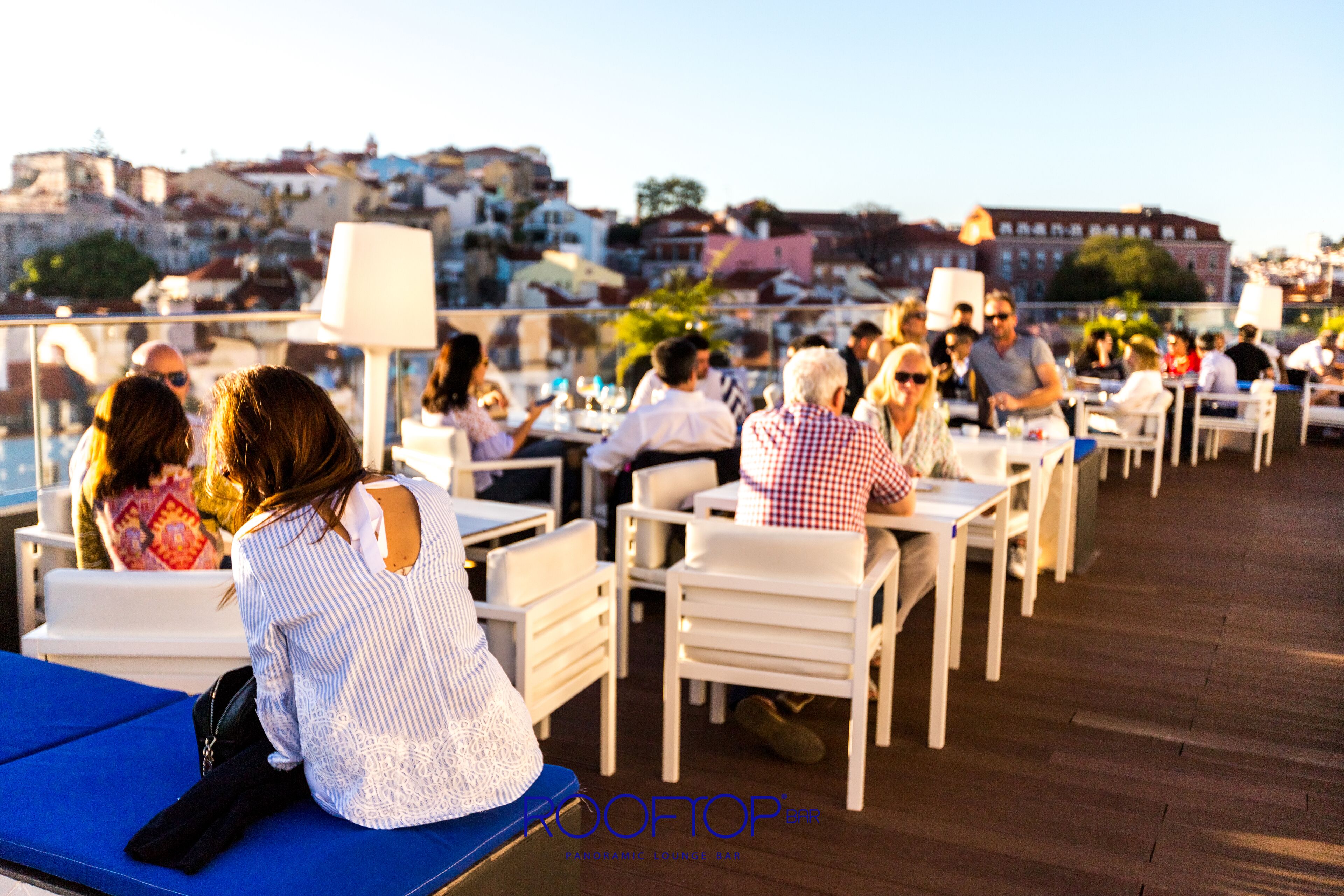 A rooftop terrace with outdoor seating and a view of the cityscape.