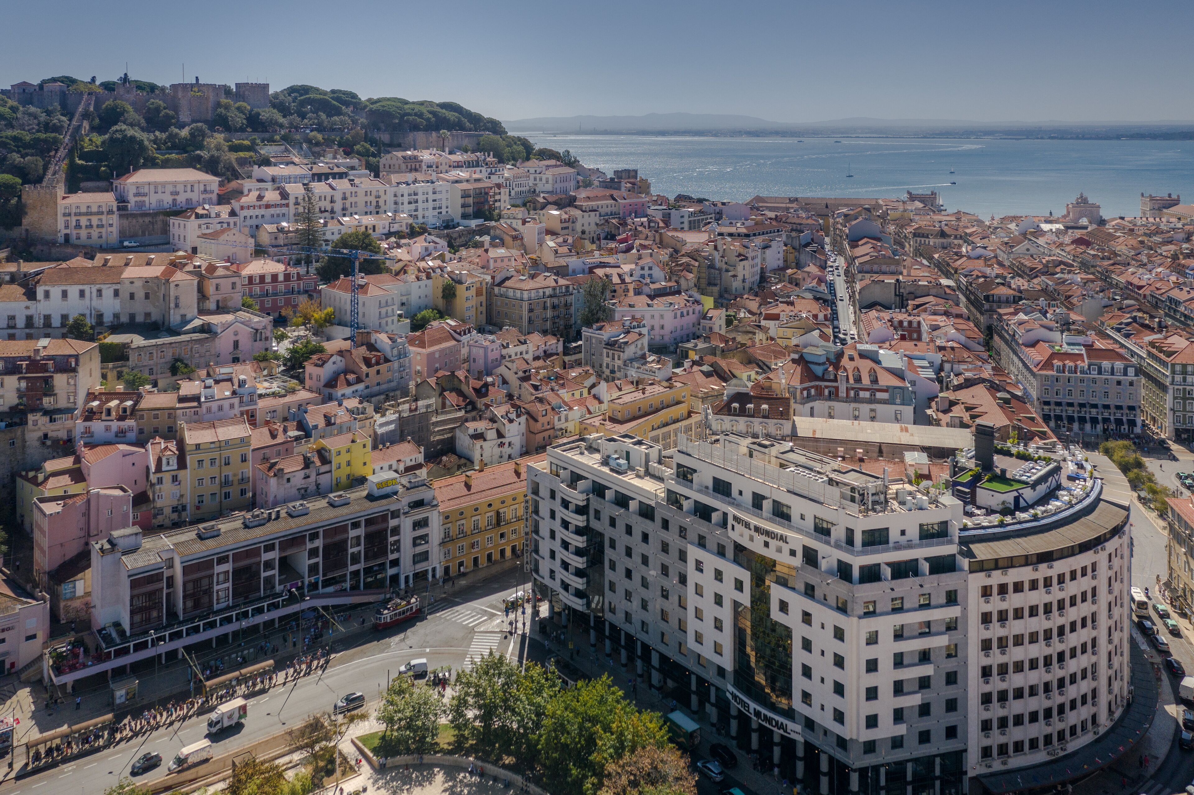Paisatge urbà amb un edifici rodó destacat que té diversos pisos i una terrassa al terrat.