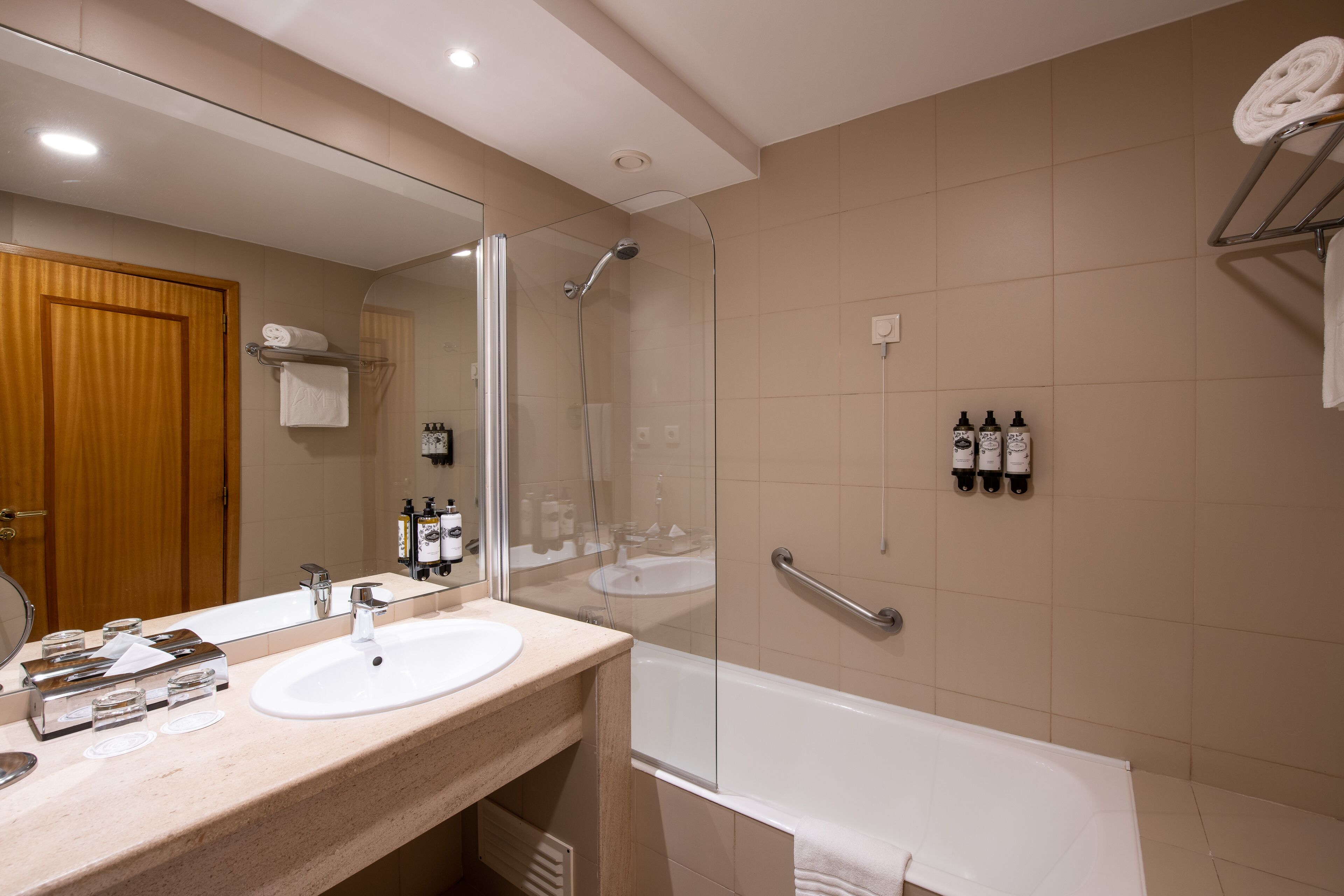Un bagno moderno con uno specchio grande, un lavandino, una doccia e una vasca da bagno.