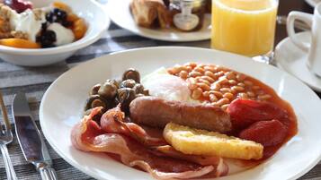 A breakfast plate with beans, sausages, bacon, eggs, and toast.