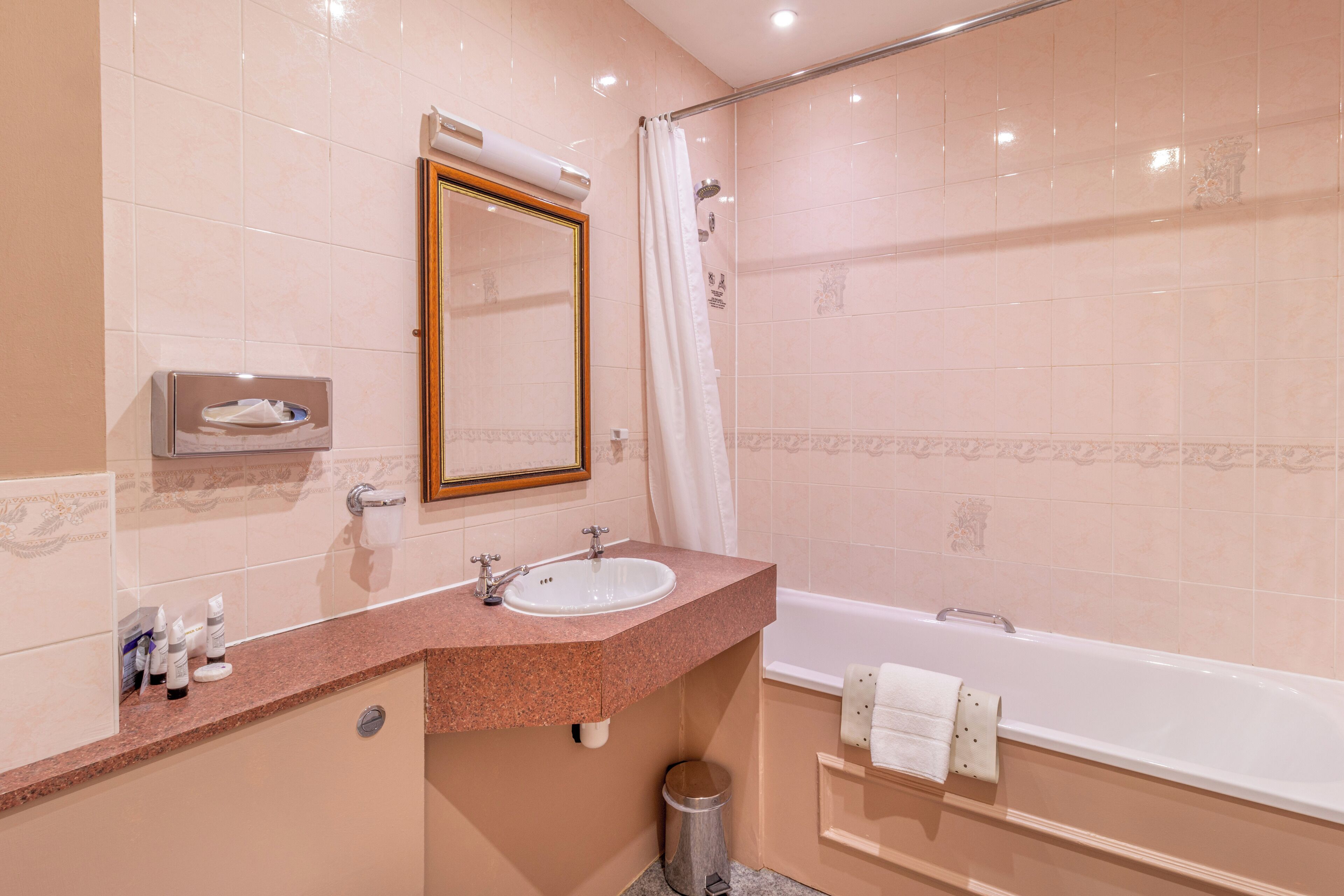 Un bagno con lavandino, specchio, doccia e vasca.