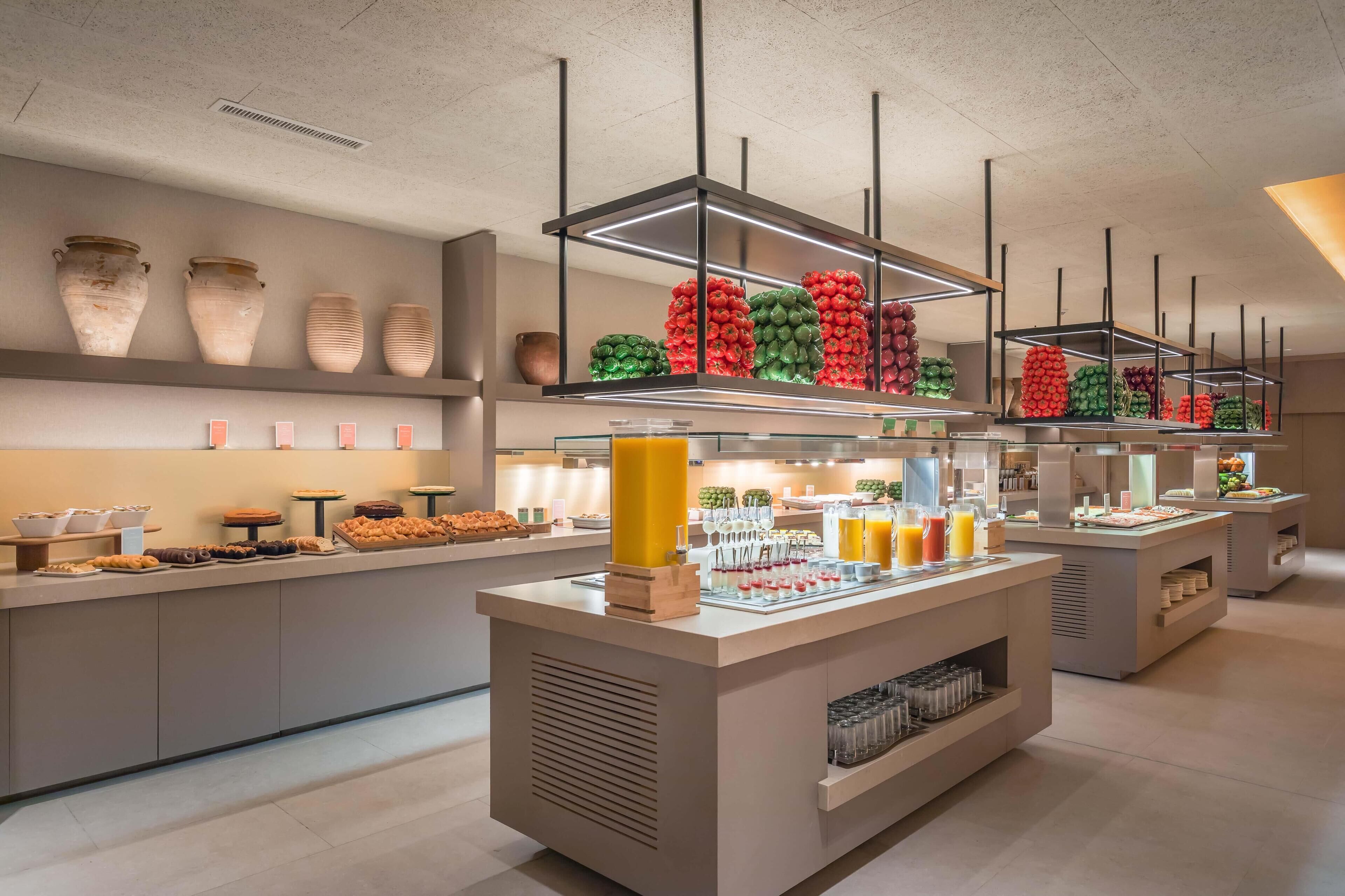 Un moderno bufé con diversas opciones de comida y jarrones decorativos.