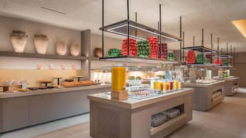 Un moderno bufé con diversas opciones de comida y jarrones decorativos.