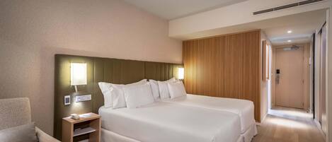 A hotel room with a large bed, bedside tables, a chair, and a wooden panel wall.