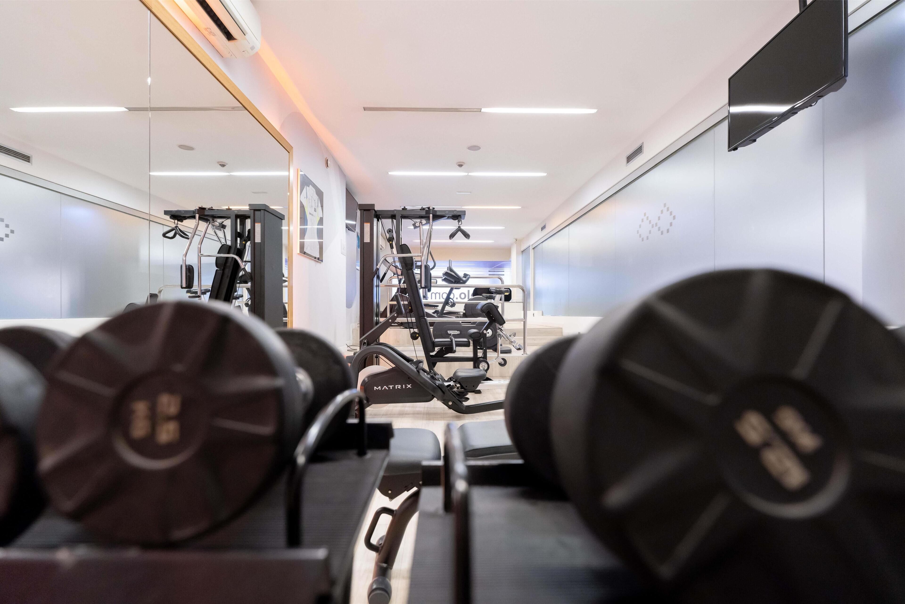 A gym with weightlifting equipment and cardio machines.