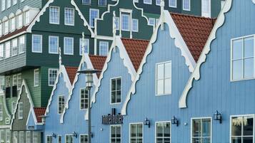 Um edifício com estilo arquitetônico marcante, com várias janelas e uma placa com a inscrição