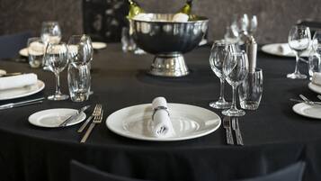 A table set for a formal dining experience with a silver bowl, wine glasses, and neatly arranged cutlery.