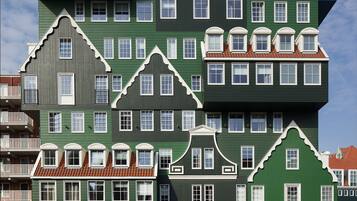 Un immeuble à plusieurs étages, doté d’une façade verdoyante et d’une enseigne indiquant « Inntel Hotels ».