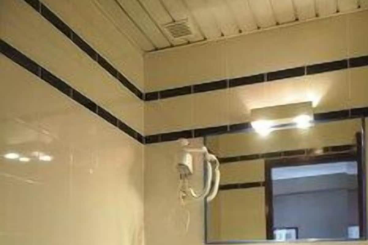 A bathroom with a toilet, sink, and mirror.