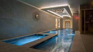 A spa area with a large indoor pool, a decorative ceiling, and a wall with a patterned design. - Romance Istanbul Hotel (Istanbul)