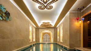 A long, narrow indoor swimming pool with a decorative ceiling and wall sconces. - Romance Istanbul Hotel (Istanbul)