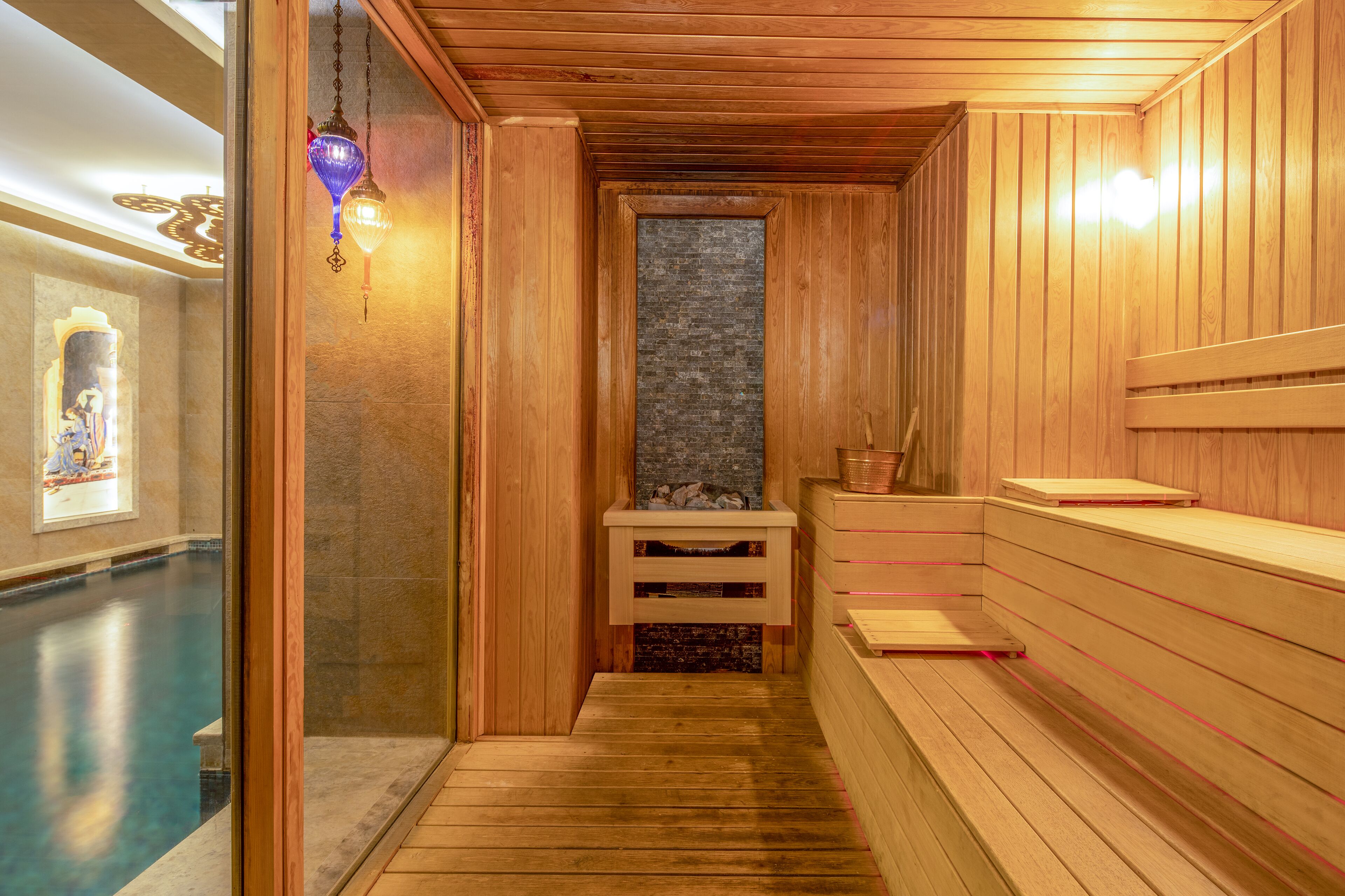 A sauna with wooden benches and a stone wall.