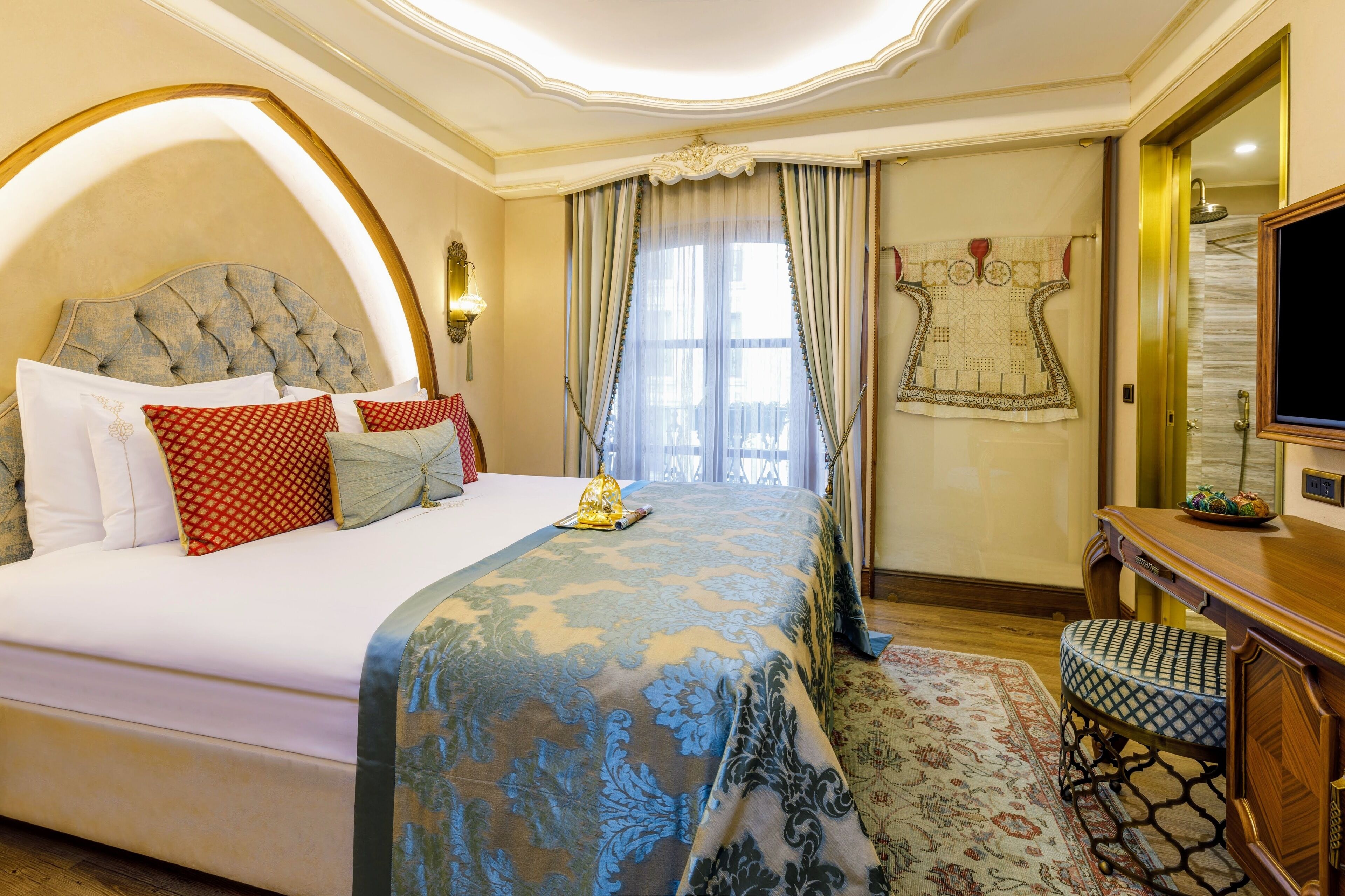A well-appointed hotel room with a large bed, a desk, and a television.