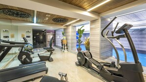 Un gimnasio moderno con cintas de correr, elípticas y equipo de pesas.