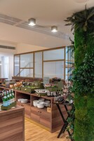 Una cucina moderna con mobili in legno, un'area buffet e una parete decorata con elementi verdi.
