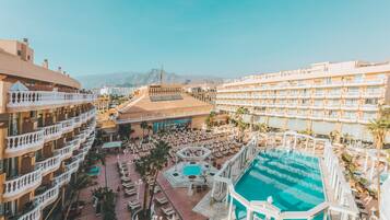 Een buitenzwembad, parasols bij het zwembad en ligstoelen