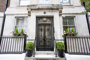 A historic building with a black wrought iron gate, a number '20' above the door, and flower boxes on either side. - Astor Court Hotel (London)