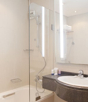 Een moderne badkamer met een douchecabine van glas, een bad en een wastafelmeubel met een wastafel.