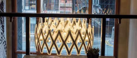 Een tafel met een decoratieve lamp voor een raam.