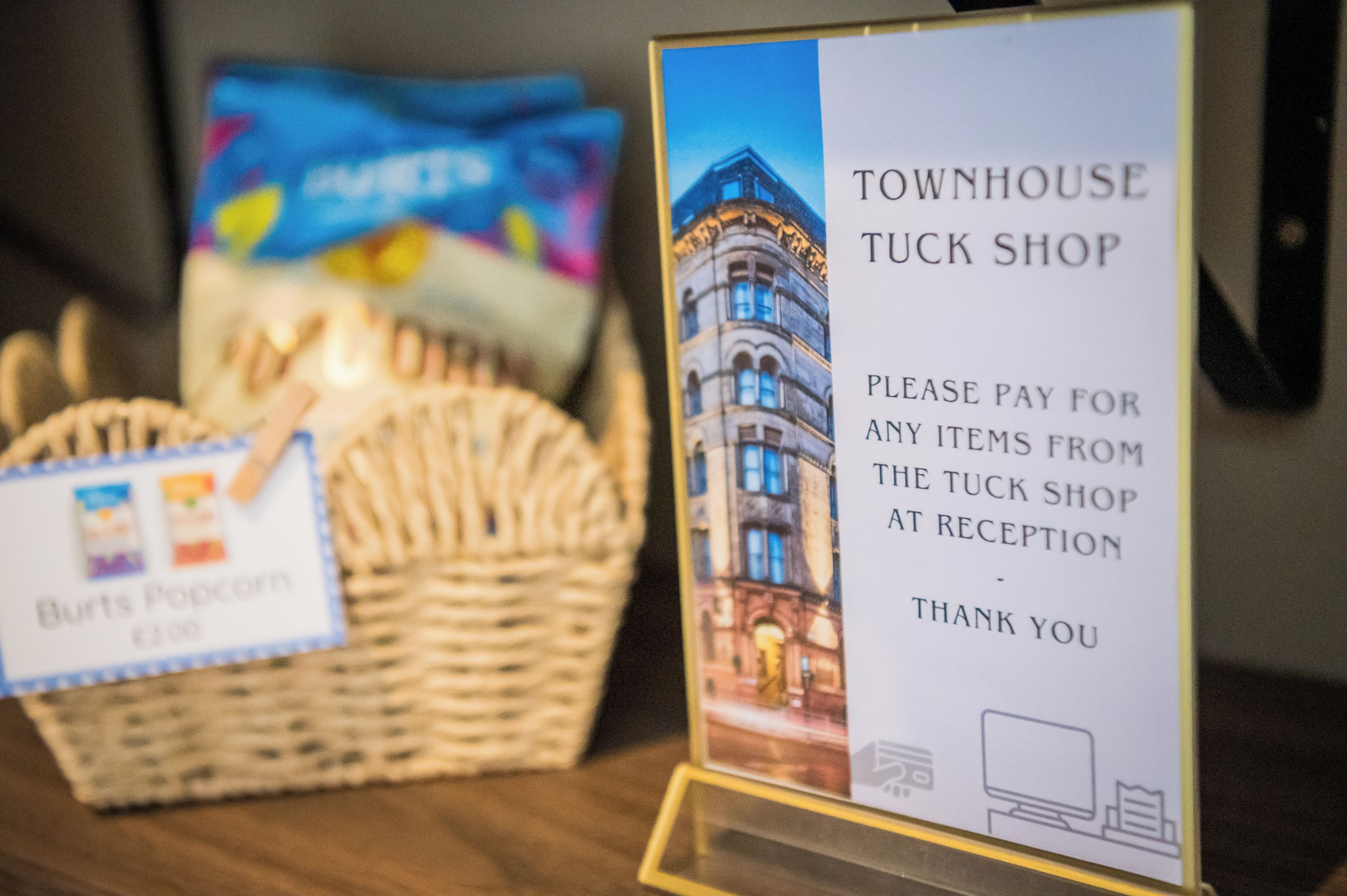 Placa da Tuck Shop do Townhouse, com pedido para pagar os artigos na receção.