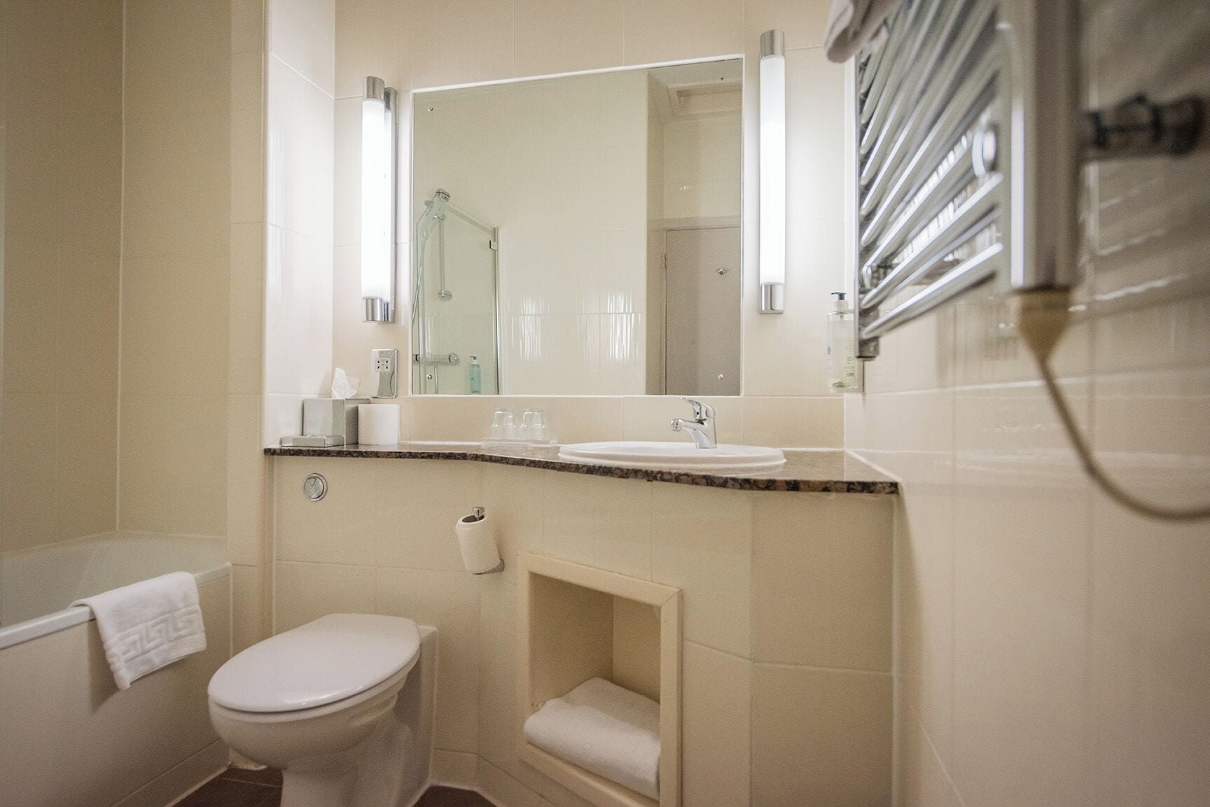 Un baño con inodoro, lavamanos y ducha.