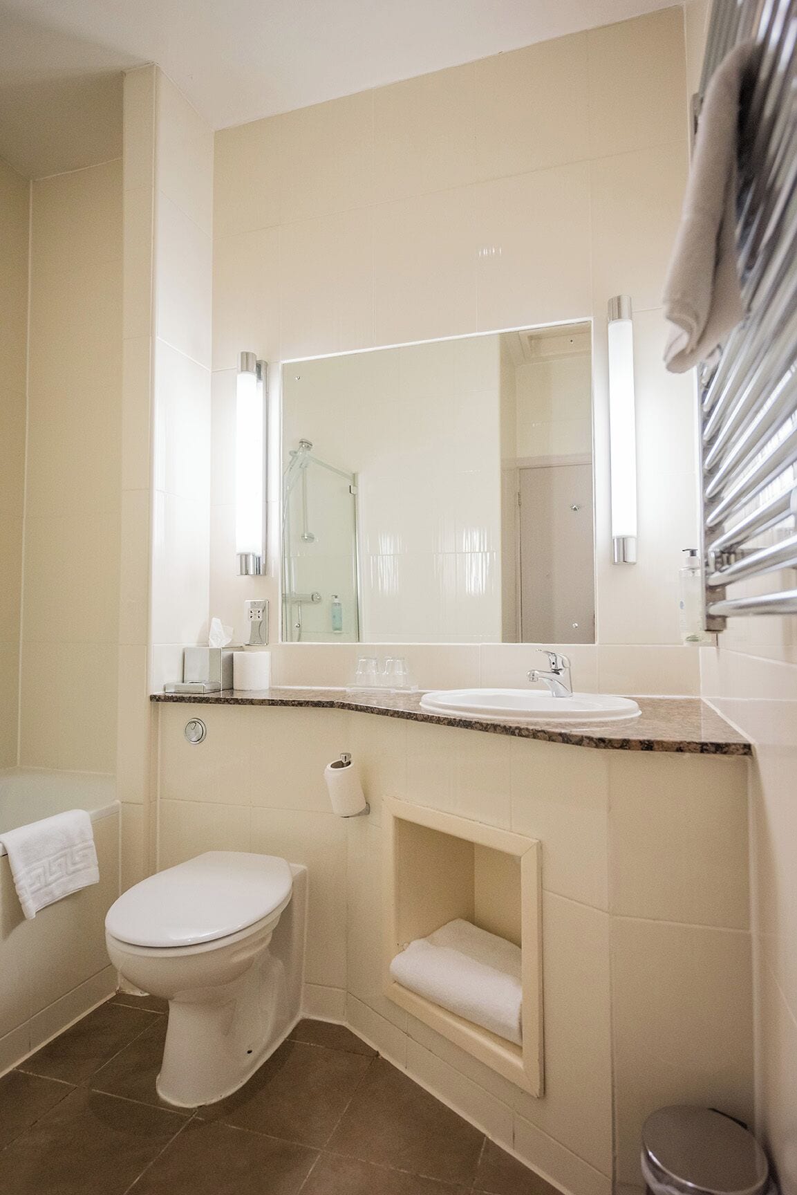 A modern bathroom with a toilet, sink, and mirror.