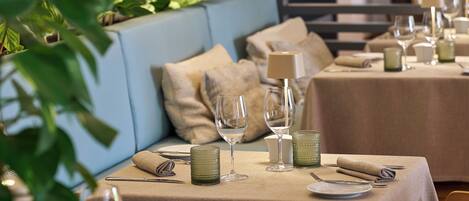 A dining area with tables set for two, featuring a neutral color scheme and modern decor.