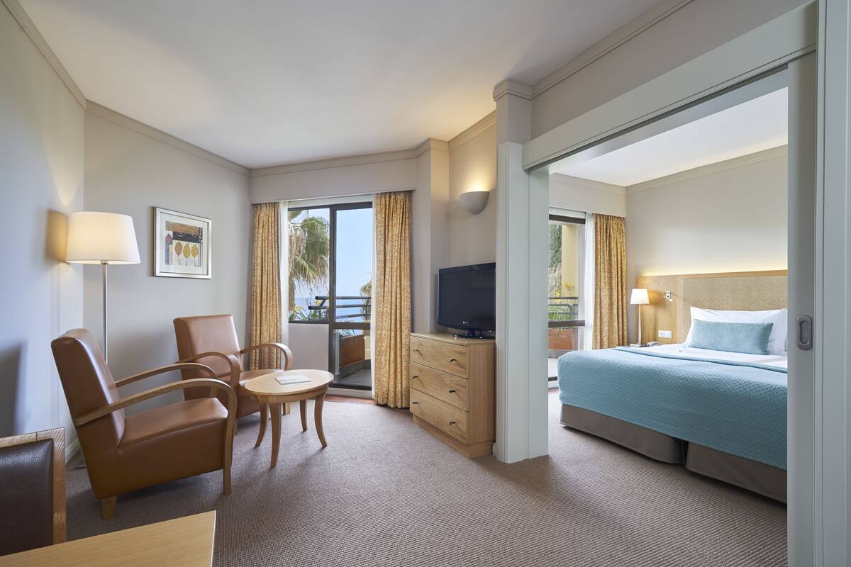 A hotel room with a bed, a TV, a desk, and a chair.