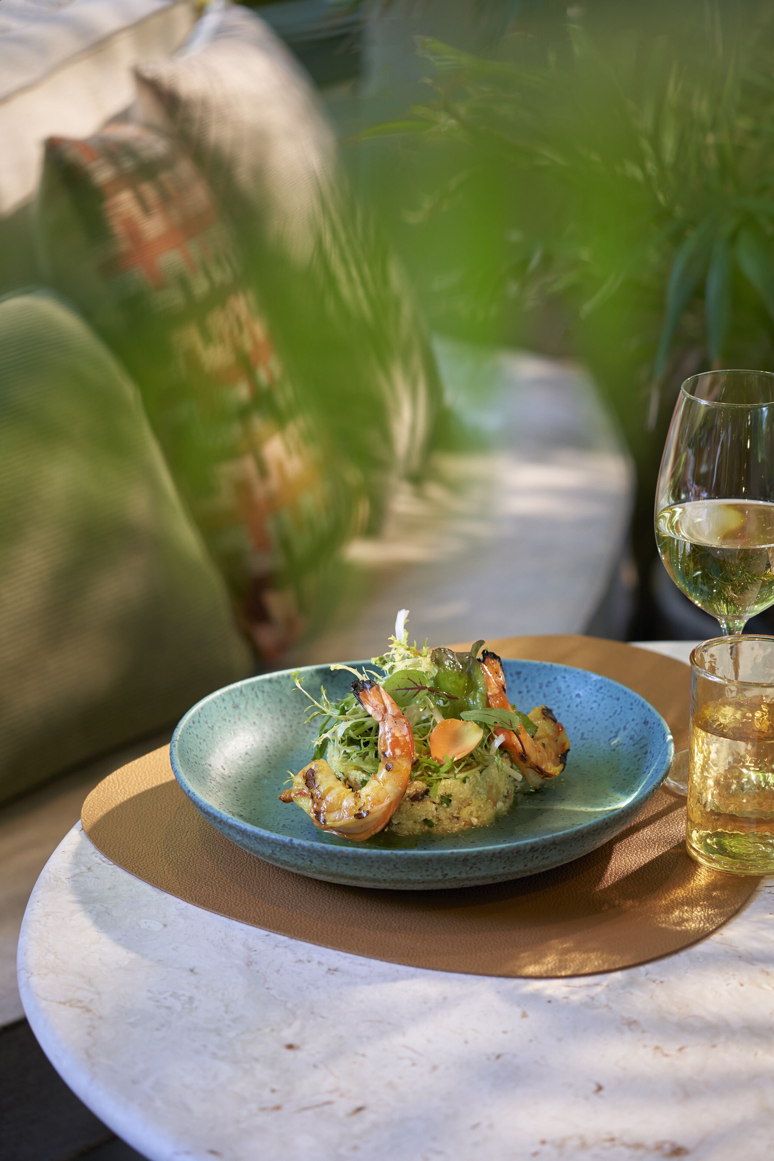 A plate of food on a table with a glass of wine.