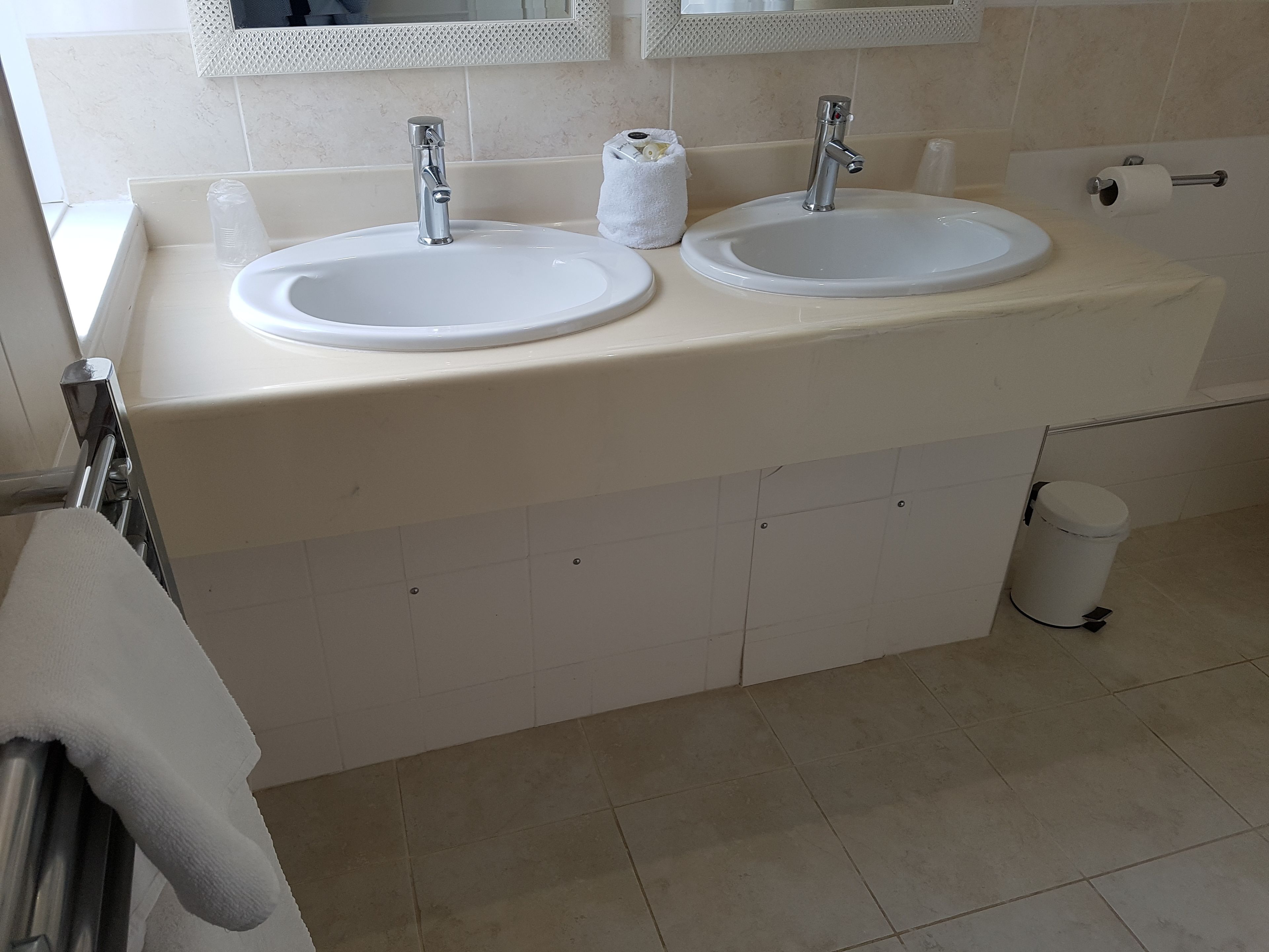 A bathroom with two sinks, a mirror above, and a toilet.