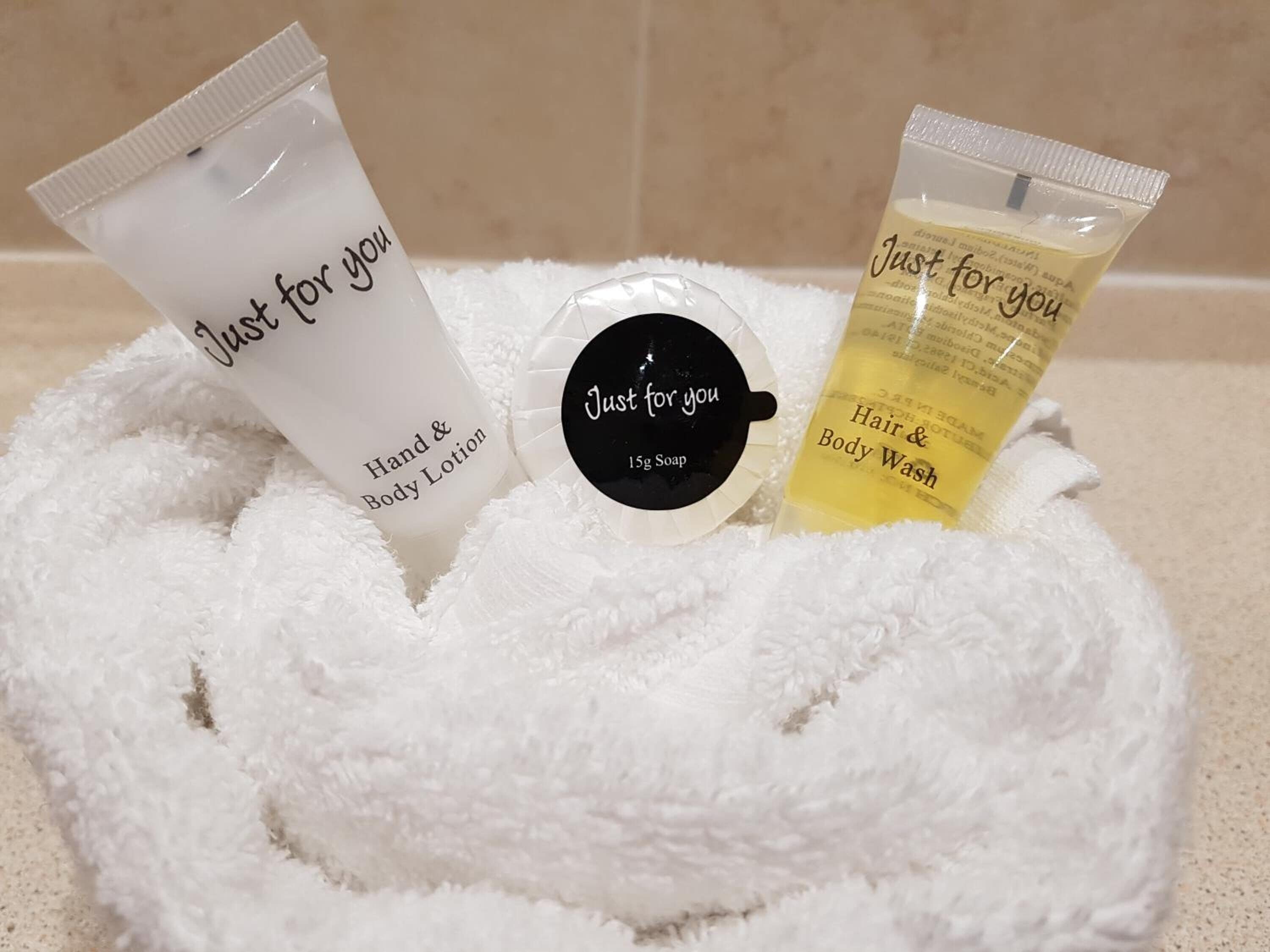 Three toiletries in a white bathrobe on a bathroom counter.