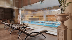 A spa area with sun loungers, a large decorative urn, and a pool with wave patterns. - Divani Apollon Palace & Thalasso (Vari-Voula-Vouliagmeni)