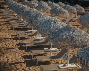 In Strandnähe, Liegestühle, Sonnenschirme, Strandtücher